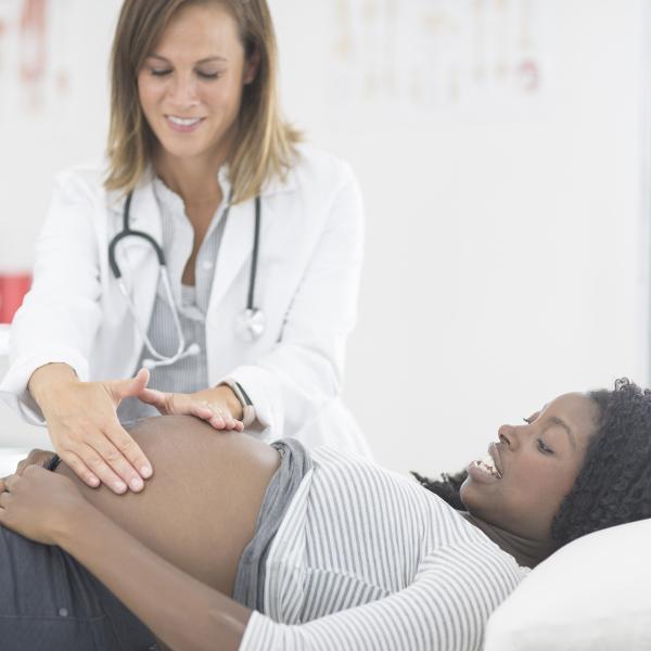 Doctor examines pregnant woman's belly