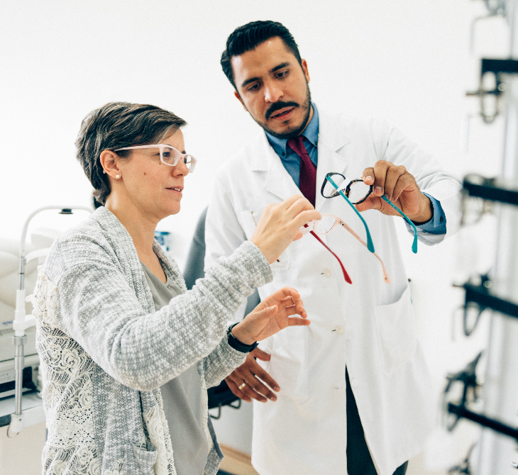 hispanic woman picking out glasses at the eye doctor