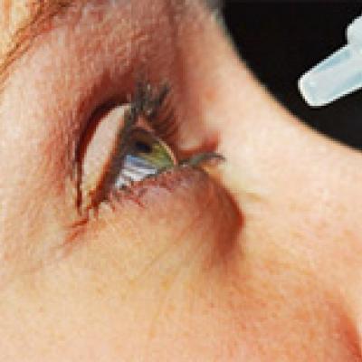 Primer plano de una persona aplicando gotas en su ojo derecho.