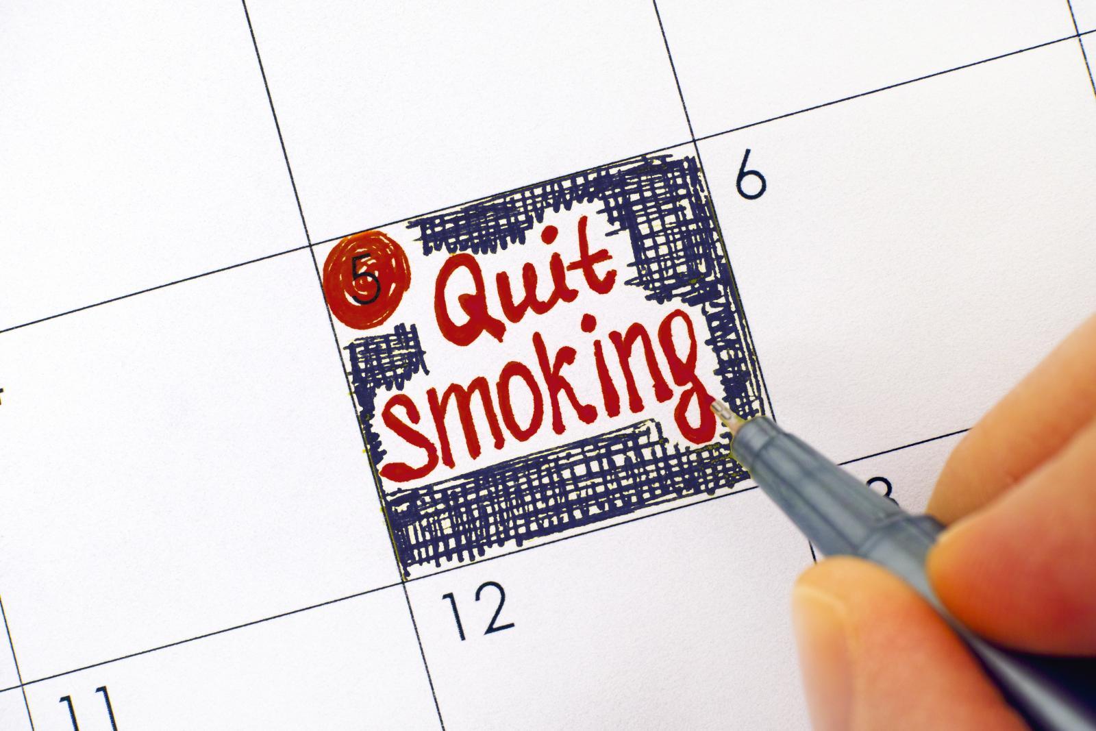Alguien escribe ‘dejar de fumar’ en un día en el calendario.