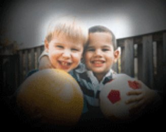 Foto de dos niños, cada uno cargando una pelota y sonriendo. En esta imagen, las esquinas se ven borrosas y oscurecidas.