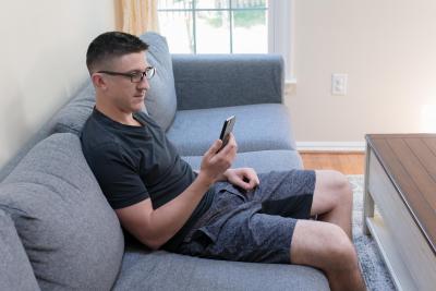 man looking at phone and sitting on sofa