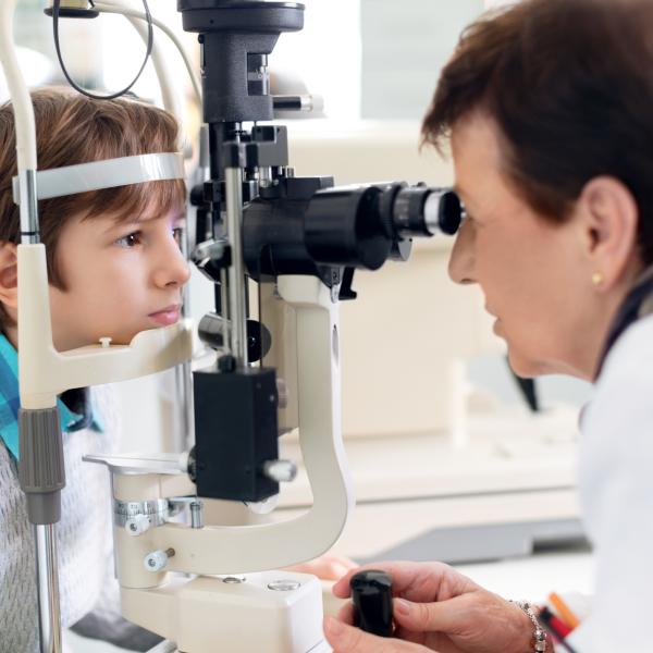 Young boy sits for an eye exam. 