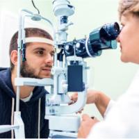 Man getting his eyes examined by a doctor using a slit lamp