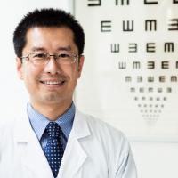 Un oculista está en frente de una tabla optométrica.