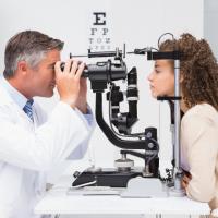 Eye doctor giving patient an eye exam.