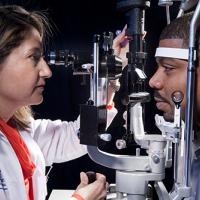 Doctor examines patient's eye using slit lamp