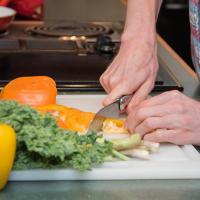 A person cuts up a bell pepper.